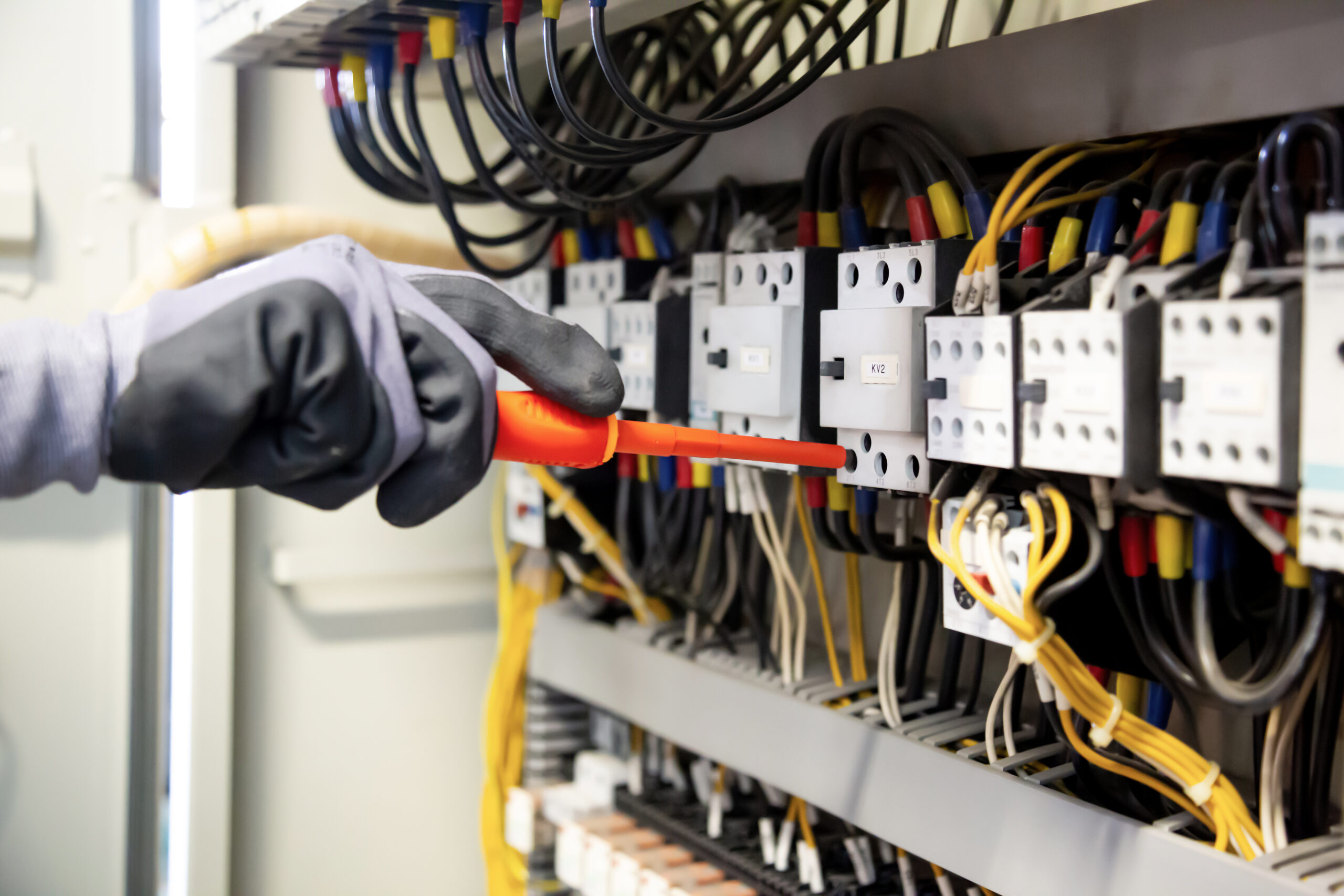 Electricians work to connect electric wires in the system, switchboard, electrical system in Control cabinet.